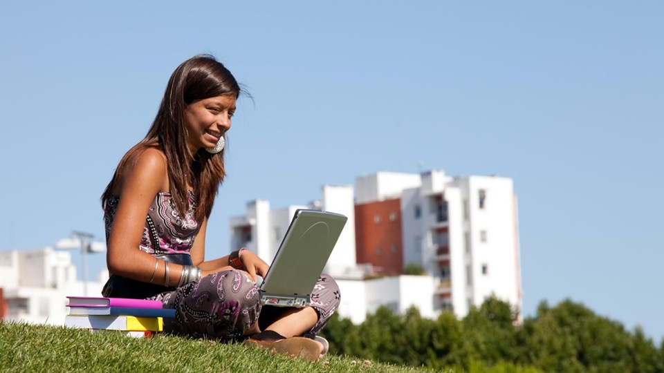 Young girl sitting outside with her laptop