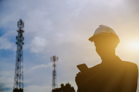 Man on his phone in front of portable cell towers