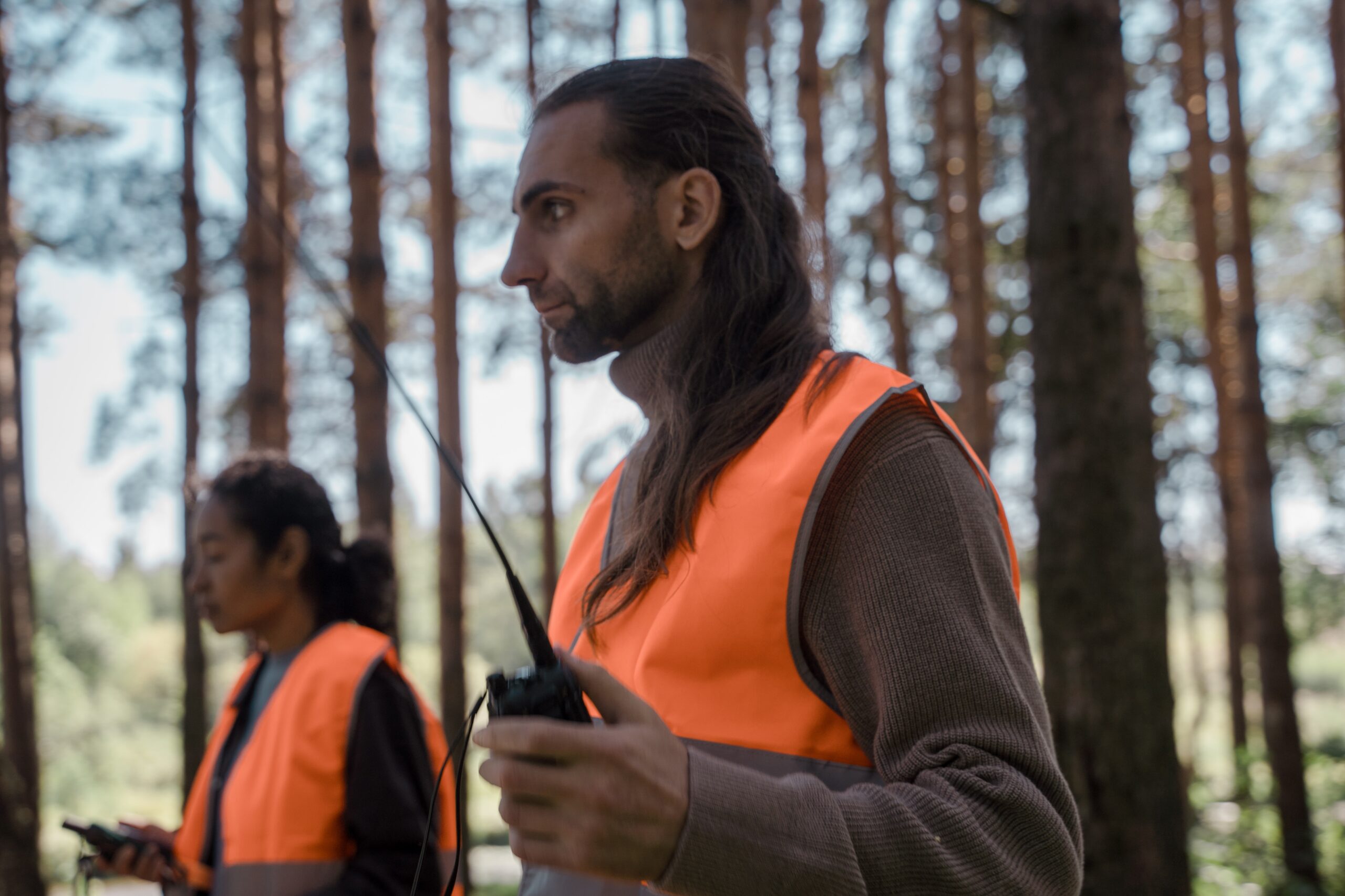 man and women using two way radios in the woods
