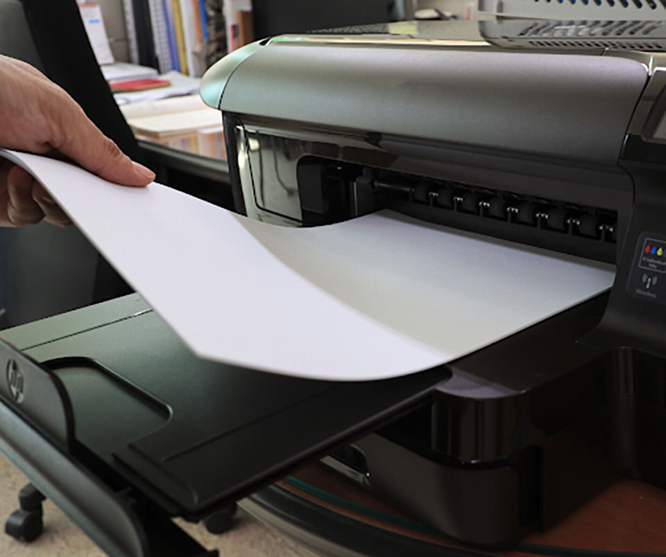 A close-up of a printer being fed a piece of paper